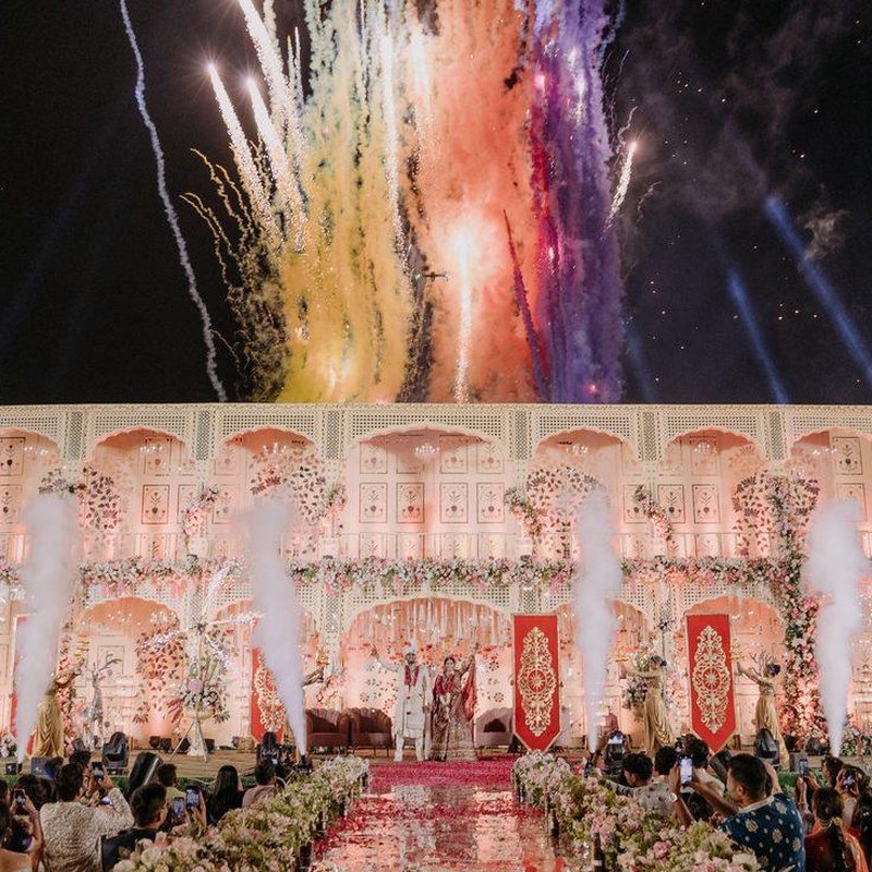 Couple on stage with fireworks during an Ekaa wedding